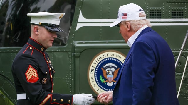 President Trump gives his challenge coins to the marine after exiting Marine One on the south lawn of the White House on May 25 in Washington, D.C. Photo: Tasos Katopodis/Getty Images