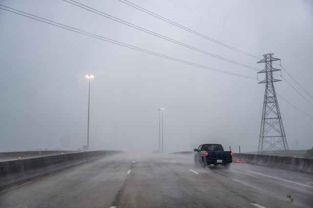 A vehicle drives through heavy rain on a highway during Hurricane Beryl on July 8, 2024, in Houston, Texas.