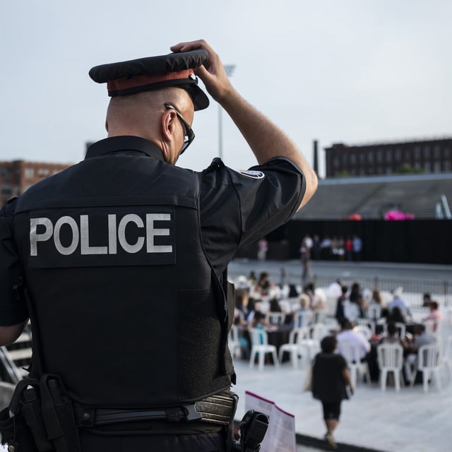An Toronto police officer walks among the crowds at Lamport Stadium during Caribana's King and Queen's competition on Thursday, July 28 in Toronto. (Christopher Katsarov for The Globe and Mail)