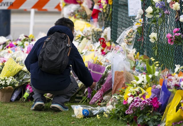 A member of the public leaves flowers a memorial site close to the location where a car drove through a crowd at the Lapu Lapu Day festival, killing multiple people in Vancouver, B.C., Monday, April 28, 2025. 
