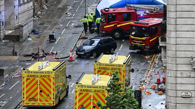 Police officers cover with an inflatable tent, behind a firefighter vehicle following an incident with a car on the sidelines of an open-top bus victory parade for Liverpool's Premier League title win, in Liverpool, northwest England on May 26. Photo: Paul Ellis /AFP via Getty Images