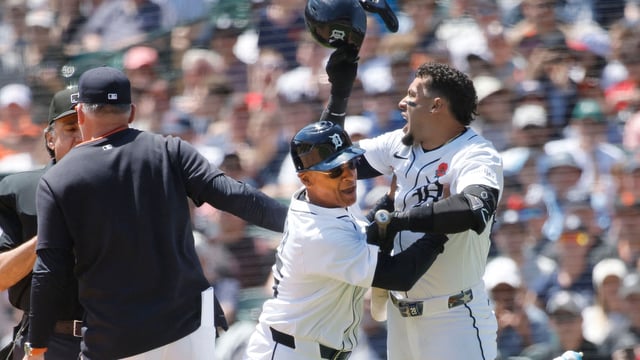 Javier Baez #28 (R) of the Detroit Tigers is held back by third base coach Joey Cora #56 after being called out on strikes as manager A.J. Hinch #14 argues with home plate umpire Phil Cuzzi in the fifth inning at Comerica Park on May 26, 2025 in Detroit, Michigan.
