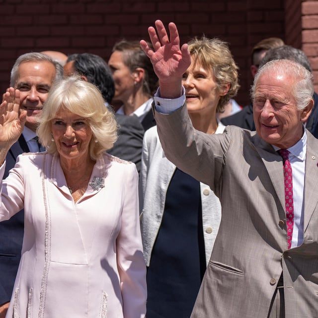 King Charles and Queen Camilla wave to the crowd as Prime Minister Mark Carney and his wife Diana Fox Carney look on prior to participating in a ceremonial puck drop  during a visit to Lansdowne Park in Ottawa on Monday, May 26, 2025. THE CANADIAN PRESS/Christinne Muschi
