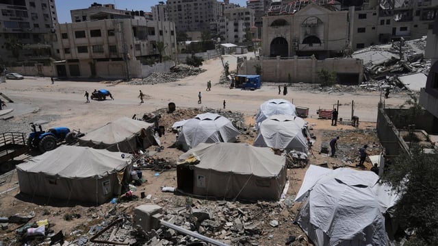 Zelte in Gaza-Stadt stehen zwischen Trümmern und zersörten Gebäuden.