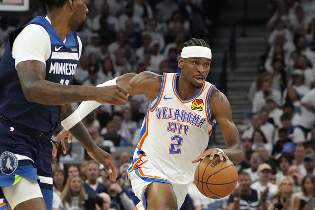 May 26, 2025; Minneapolis, Minnesota, USA; Oklahoma City Thunder guard Shai Gilgeous-Alexander (2) dribbles the ball past Minnesota Timberwolves center Naz Reid (11) in the first half during game four of the western conference finals for the 2025 NBA Playoffs at Target Center. Mandatory Credit: Bruce Kluckhohn-Imagn Images