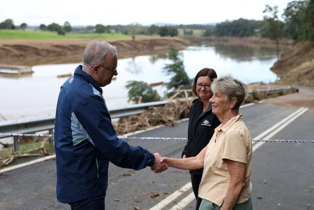 Australia's Prime Minister Anthony Albanese shakes hands with a local woman Lyn Latimore on the day he visits flood affected area, in Wingham, Australia, May 27, 2025. REUTERS/Hollie Adams