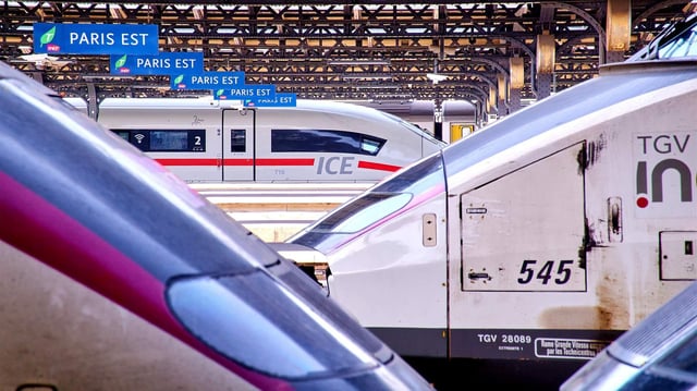 Ein ICE der Deutschen Bahn am Gleis im Bahnhof Paris Est, im Vordergrund zwei französische TGV-Züge