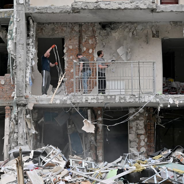 Local residents of a multistory residential building clear debris from a flat damaged following a drone strike in Kyiv on May 25, 2025, amid Russian invasion in Ukraine. Russia launched a record number of drones against Ukraine and killed 12 people across the country, officials said on May 25, even as Kyiv and Moscow completed their biggest prisoner exchange since the start of the war. (Photo by Sergei SUPINSKY / AFP) (Photo by SERGEI SUPINSKY/AFP via Getty Images)