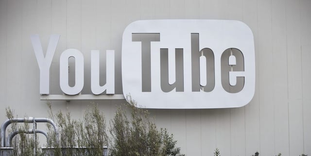 People hold up laptops while filming a video underneath signage outside a YouTube Inc. office in the Playa Vista neighborhood of Los Angeles, California, U.S., on Thursday, Feb. 2, 2017. The surge in online television viewing is spurring a wave of big real estate deals, as companies such as Netflix, Amazon.com Inc. and Google snap up space to cope with increased production demands. Photographer: Patrick T. Fallon/Bloomberg via Getty Images