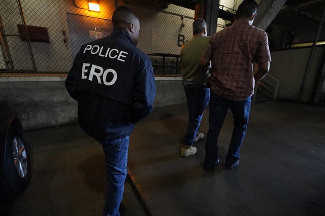U.S. Immigration and Customs Enforcement agents transfer an immigrant into the ICE Metropolitan Detention Center in Los Angeles, after an early morning raid, Monday, June 6, 2022.