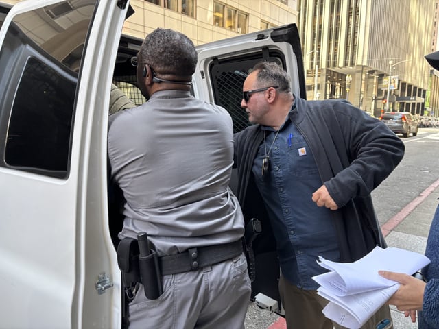 Officials bundle a man into an umarked van out San Francisco's immigration court on Tuesday morning, May 27, 2025.