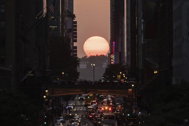 FILE - The sun sets as seen between buildings along 42nd Street in New York, May 30, 2023. (AP Photo/Yuki Iwamura, file)