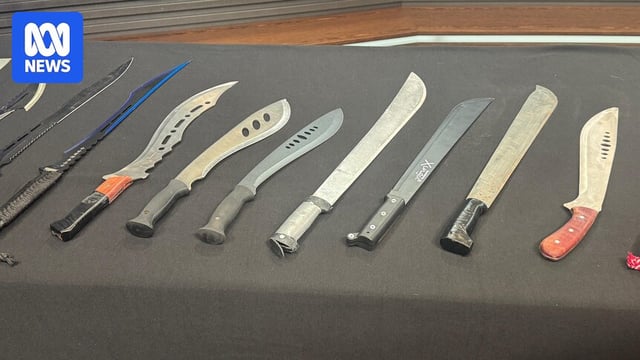 A table with lots of long knives laid out.