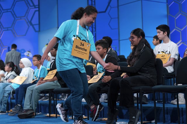 Blanche Yang Li, 14, of Boulder, Colo., high fives her friends after correctly spelling her word as she competes during the first preliminary round of the Scripps National Spelling Bee at the Gaylord National Resort & Convention Center, Tuesday, May 27, 2025, in Oxon Hill, Md. (AP Photo/Jose Luis Magana)g