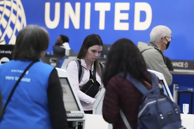 Travelers print their boarding passes at kiosks inside of O'Hare International Airport in Chicago, Friday, May 23, 2025. (AP Photo/Nam Y. Huh)