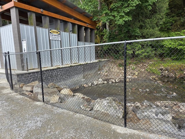 A fence and structure are seen at the pools known as the Hobo Hot Spring, near the village of Harrison Hot Springs, B.C., in this Monday, May 26, 2025, handout photo provided by the community's mayor, Fred Talen. The British Columbia government has ordered that the free and natural spring be repaired after it was filled with dirt and boulders in October 2024. , 