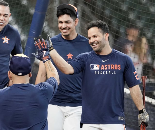 Houston Astros designated hitter Jose Altuve, right, gives a high-five to third baseman Isaac Paredes during batting practice before an MLB baseball game in Houston, Tuesday, May 27, 2025.