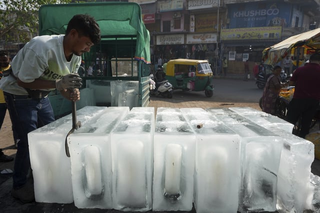 FILE - A man arranges ice blocks to sell at his stall in Ahmedabad, India, April 2, 2025. (AP Photo/Ajit Solanki, File)