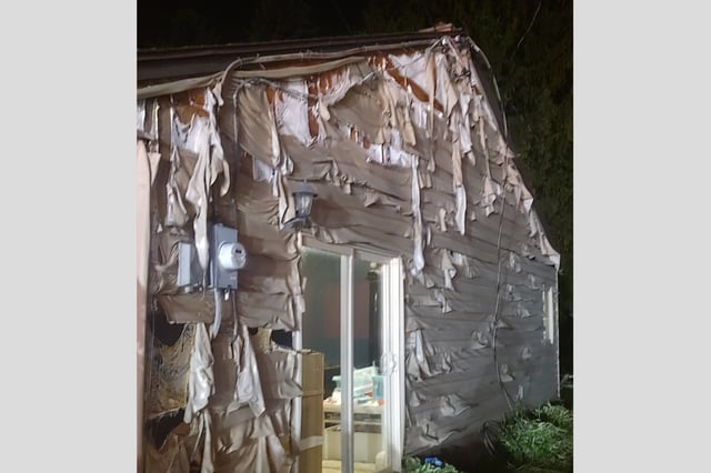 Melted siding is shown after a fire.