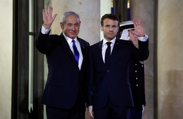 French President Emmanuel Macron and Israeli Prime Minister Benjamin Netanyahu wave as Netanyahu arrives for a dinner at the Elysee Palace, in Paris, France, February 2, 2023. REUTERS/Benoit Tessier/File Photo