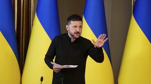 Der ukrainische Präsident Wolodymyr Selenskyj äußert sich mit erhobener Hand während einer Pressekonferenz