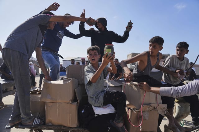 Palestinians carry boxes containing food and humanitarian aid packages delivered by the Gaza Humanitarian Foundation, a U.S.-backed organization approved by Israel, in Rafah, southern Gaza Strip, on Tuesday, May 27, 2025.