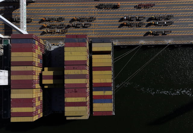 A container ship is pictured being unloaded at the Port of Oakland in May 2025 in Oakland, California.
