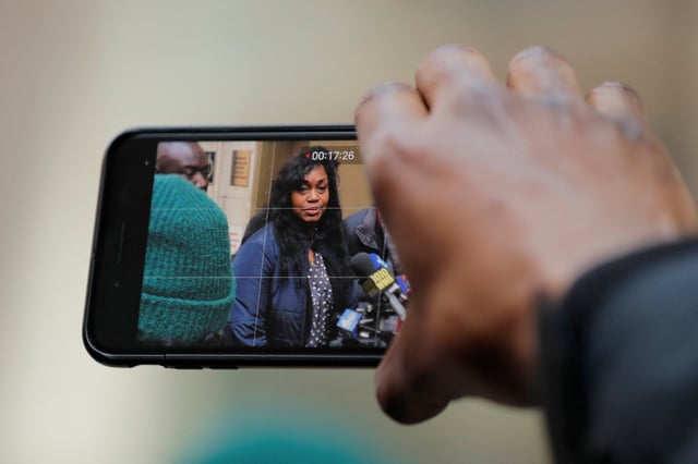 A man uses his phone to take video of Tamara Lanier speak to the media about a lawsuit accusing Harvard University of the monetization of photographic images of her great-great-great grandfather, an enslaved African man named Renty, and his daughter, Delia outside of the Harvard Club in New York, U.S., March 20, 2019. REUTERS/Lucas Jackson/File Photo