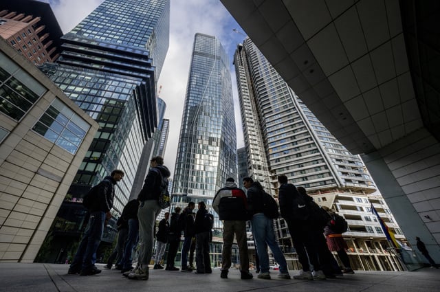 FILE - People stand in front of the city's largest construction site with four new high-rise buildings in Frankfurt, Germany, Sept. 24, 2024. (AP Photo/Michael Probst, file)