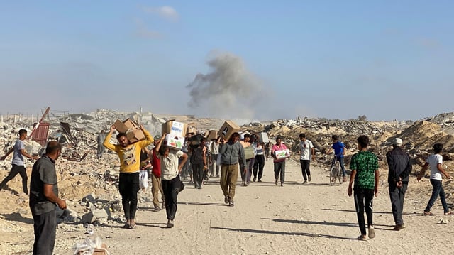 Displaced Palestinians receive food packages from a US-backed foundation pledging to distribute humanitarian aid in western Rafah in the southern Gaza Strip 