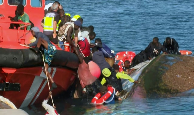 Image tirée d'une vidéo diffusée par Television Canaria montrant des sauveteurs tentant de sauver des migrants de la noyade après le chavirement de leur bateau surchargé, dans le port de La Restinga, sur l'île d'El Hierro, le 28 mai 2025 aux Canaries