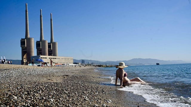 Una mujer se moja las piernas en la playa del Litoral de Sant Adrià de Besòs, reabierta tras llevar a cabo tareas de descontaminación.