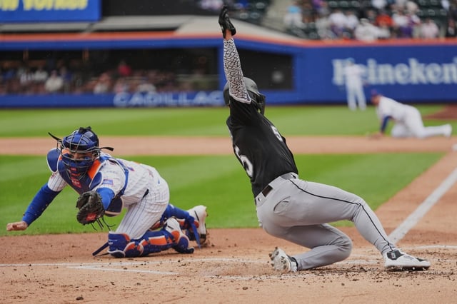 Chicago White Sox&#39;s Josh Rojas (5) slides past New York Mets catcher Luis Torrens to score on a two-run double during the second inning of a baseball game Wednesday, May 28, 2025, in New York. (AP Photo/Frank Franklin II)