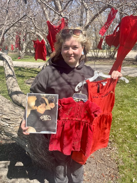  Shahla Hoeppner with her mother’s photo and red dress, as well as a smaller dress representing her baby sister.