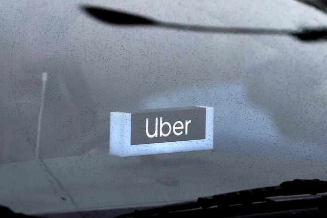 FILE: An Uber sign is displayed inside a car on May 15, 2020, in Chicago.