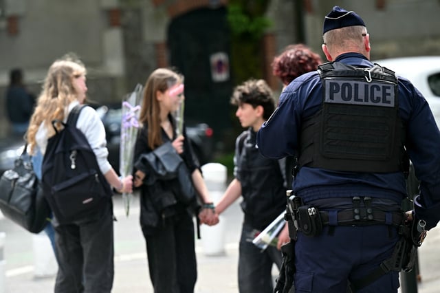 Un policier près d’élèves du lycée Notre-Dame de Toutes-Aides, à Nantes, au lendemain d’une attaque au couteau survenue le 25 avril, au cours de laquelle une élève a été tuée et trois autres blessés.