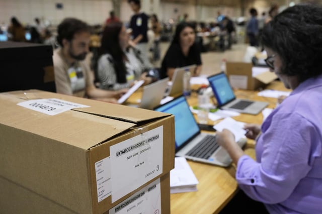 Boxes which arrived from New York and Boston containing votes for Portugal's May 18 general election are stacked on a desk where volunteers are registering them on the final day of counting of ballots from voters who live abroad, in Lisbon, Wednesday, May 28, 2025. (AP Photo/Armando Franca)