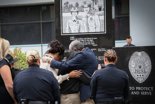 Members of the Machitar family hug during an annual memorial ceremony to honor fallen San Diego police officers Wednesday. Officer Austin Machitar’s name was the latest to be added to the memorial. (Sandy Huffaker / For The San Diego Union-Tribune)