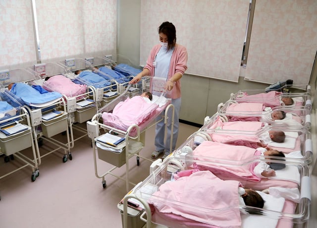 Hospital staff attend to babies in the nursery ward of the Hospital in Misato city, Saitama prefecture, Japan.