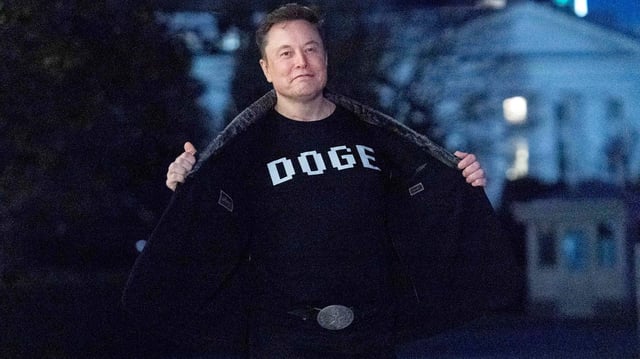 Elon Musk zeigt den Medien sein T-Shirt mit der Aufschrift "DOGE".