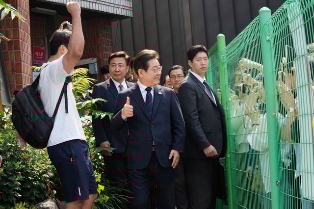 South Korean Democratic Party's presidential candidate Lee Jae-myung, center, reacts as he leaves after casting his early vote for the June 3 presidential election near a polling station in Seoul, South Korea, Thursday, May 29, 2025. (AP Photo/Ahn Young-joon)