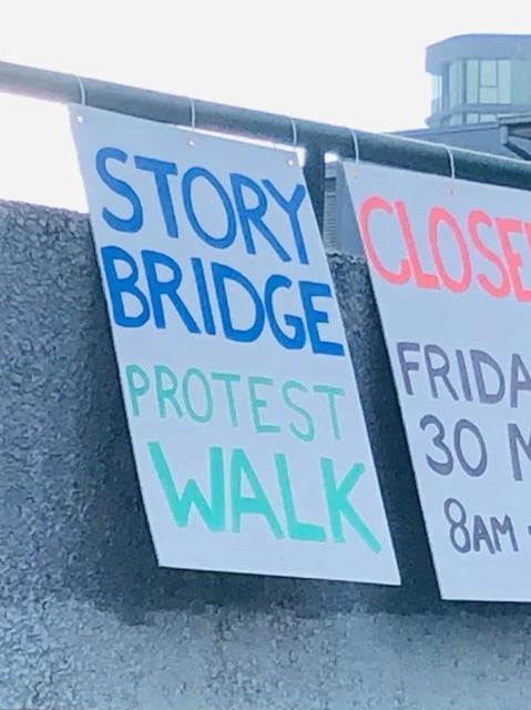 Protest signs near the Story Bridge warning drivers of a pending protest which the courts have blocked