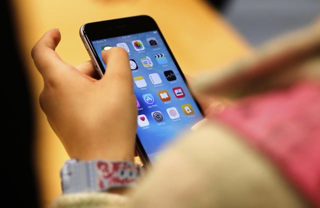 FILE - A child holds an iPhone at an Apple store on Sept. 25, 2015 in Chicago. (AP Photo/Kiichiro Sato, File)
