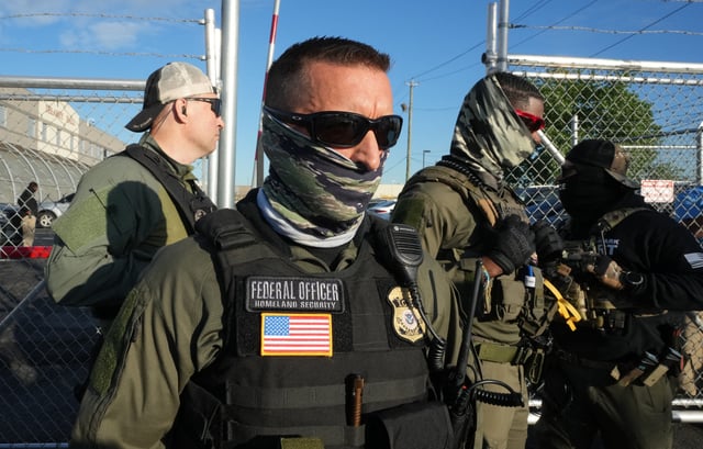 Immigration and Customs Enforcement (ICE) agents stand near a gate at Delaney Hall, a newly converted immigrant detention centre in Elizabeth, New Jersey May 7, 2025.
