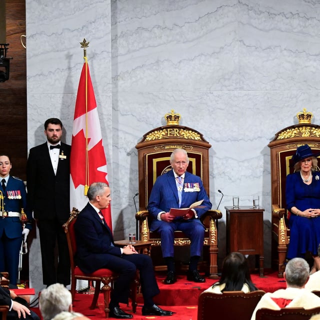 Canada's Prime Minister Mark Carney sits near King Charles III and Queen Camilla, in the Senate Chamber at the Senate of Canada Building for the State Opening of the Parliament of Canada, as part of the Royals' two-day visit to Canada, in Ottawa May 27, 2025.   Victoria Jones/Pool via REUTERS