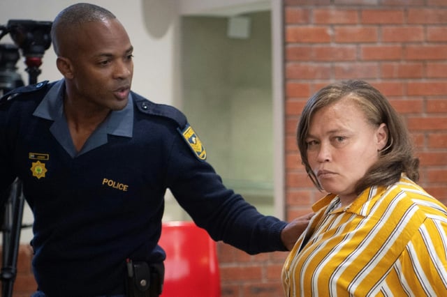 Kelly Smith (D) mère de la fillette Joshlin, à côté d'un agent du service de police sud-africain (SAPS) après avoir été reconnue coupable avec ses coaccusés de traite d'êtres humains et d'enlèvement, à Saldanha Bay, le 2 mai 2025