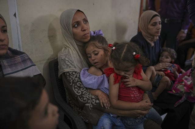 Palestinian women wait with their sick children for medical care in an overcrowded clinic in Gaza City, Wednesday, May 28, 2025. (AP Photo/Jehand Alshrafi)