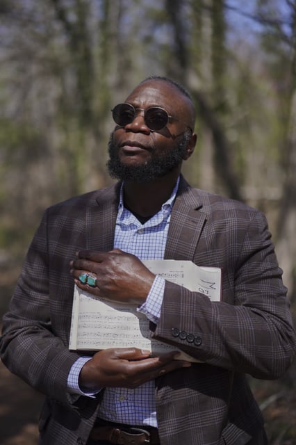Bridge Hill Kennedy, poses for a portrait with his copy of "The Sacred Harp" songbook opened to the favorite song of his late nephew, at Holly Springs Primitive Baptist Church in Bremen, Ga., on Sunday, March 23, 2025. (AP Photo/Jessie Wardarski)