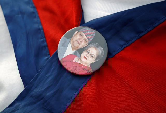A Pro-monarchy supporter affiliated with Rastriya Prajatantra Party (RPP) with a badge of former King of Nepal Gyanendra Bir Bikram Shah Dev and former Queen Komal Rajya Laxmi Devi Shah takes part during a protest demanding the restoration of constitutional monarchy in Kathmandu, Nepal April 8, 2025. REUTERS/Navesh Chitrakar/File Photo