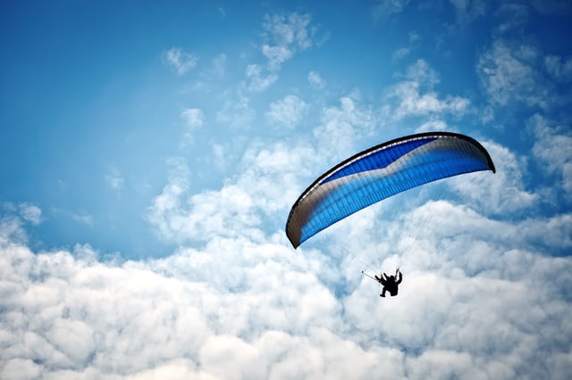 A stock image of a paraglider in the sky. On TikTok a man was filmed swooping down to a grassy area in Sydney to warn people of the police&#39;s imminent arrival.